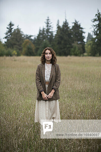Porträt eines siebzehnjährigen Mädchens mit Tweed-Blazer  stehend in einem Feld mit hohen Gräsern  Discovery Park  Seattle  Washington