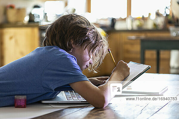 Young boy tracing on his laptop computer