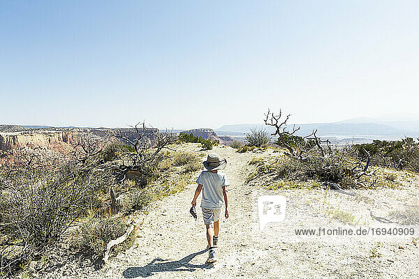kleiner Junge beim Wandern auf dem Chimney Rock Trail  durch eine geschützte Canyonlandschaft