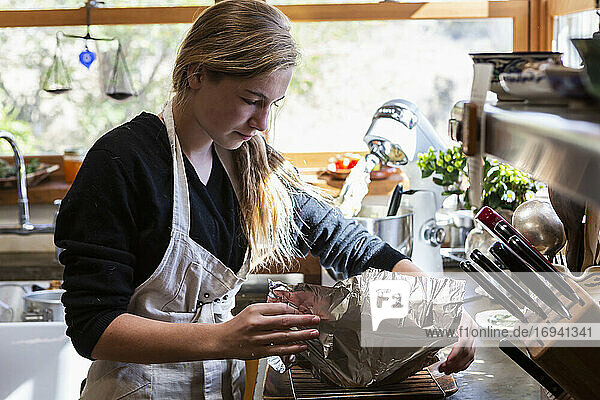 Teenager-Mädchen in der Küche backen einen Kuchen.