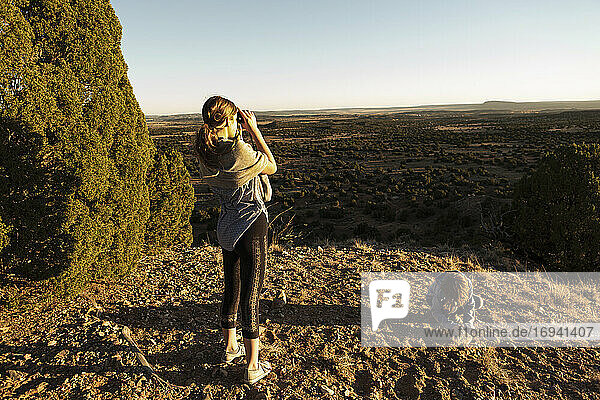 Teenager-Mädchen schaut durch ein Fernglas im Galisteo Basin