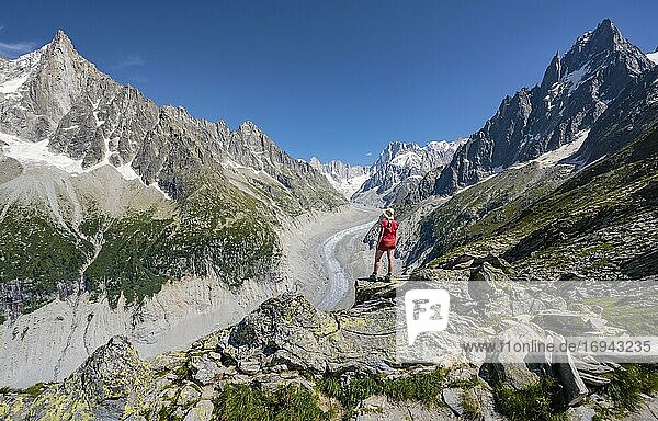 Bergsteigerin steht auf Felsen  Grand Balcon Nord  Gletscherzunge Mer de Glace  hinten Grandes Jorasses  Mont-Blanc-Massiv  Chamonix  Frankreich  Europa
