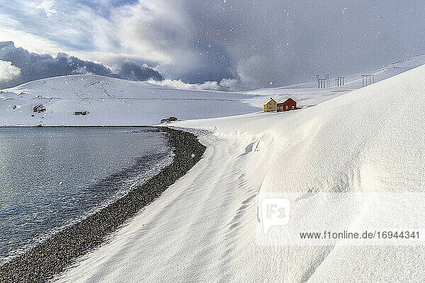 Schneefall auf den einsamen Holzhäusern mit Blick auf das arktische Meer  Skarsvag  Nordkapp  Troms og Finnmark  Nordnorwegen  Skandinavien  Europa