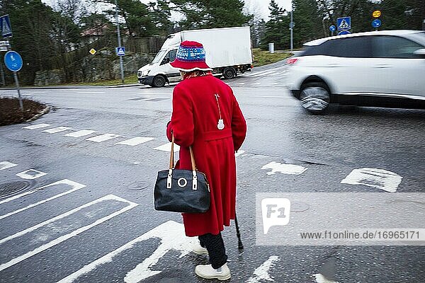 Stockholm  Sweden A senior woman walking over a crosswalk.