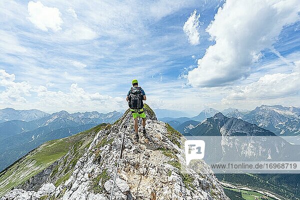 Mountaineer on a ridge on a secured via ferrata  Mittenwalder Höhenweg  view into the Isar valley near Mittenwald  Karwendel Mountains  Mittenwald  Bavaria  Germany  Europe