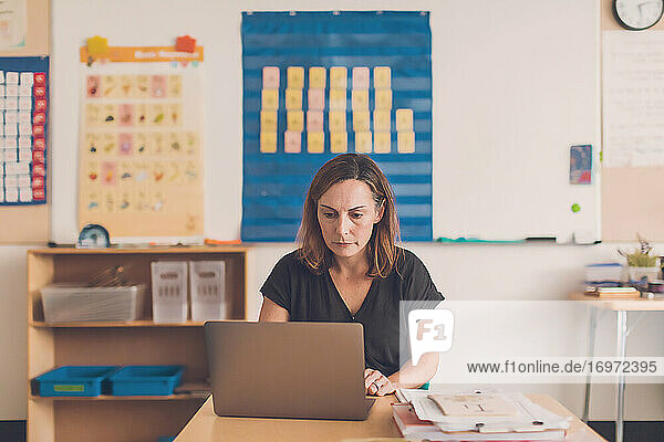 Grundschullehrerin bei der Arbeit an ihrem Laptop.