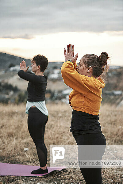 2 junge Frauen beim Pilates-Training auf dem Lande