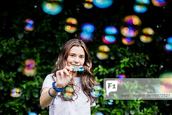 Teenager Catches a Bubble While Surrounded by Iridescent Color