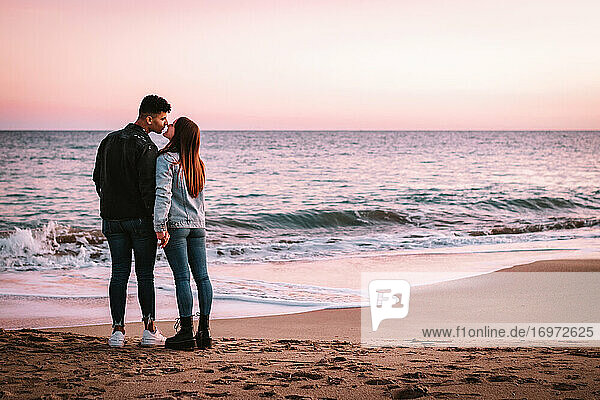Far Shot Of A Couple In Love Kissing In Front Of The Sea