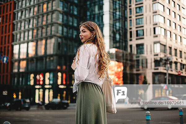 Portrait of thoughtful young woman standing on street in city
