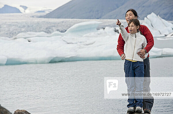 Mutter und Tochter erkunden eine Gletscherlagune in Island