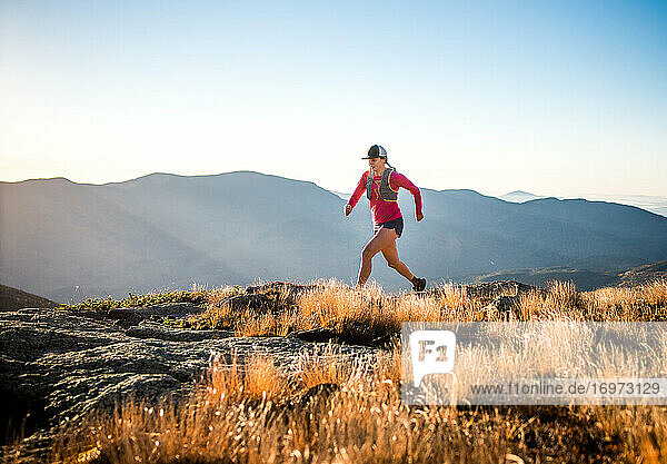 Woman running in the White Mountains at sunrise in summer