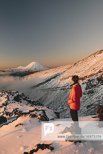 Junge Frau mit roter Jacke beobachtet den Berg Ngauruhoe Whakapapa Ski Resort  Tongariro National Park  Neuseeland
