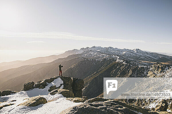 Junger Mann fotografiert bei Sonnenuntergang vor einer schneebedeckten Bergkette  Gredos  Spanien