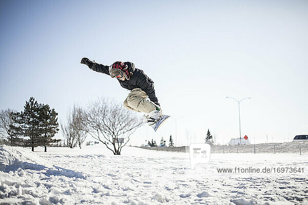 Junger Snowboarder in der Luft beim Sprung