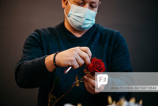 Happy kaukasischen Florist machen Verkauf von roten Rosen für Valentinstag