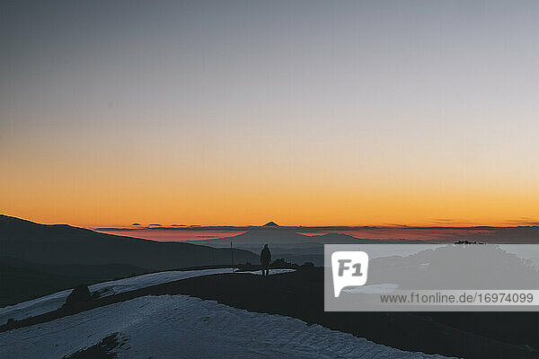 Young woman standing at the crater ridge against Mt Taranaki during sunset  Tongariro  New Zealand