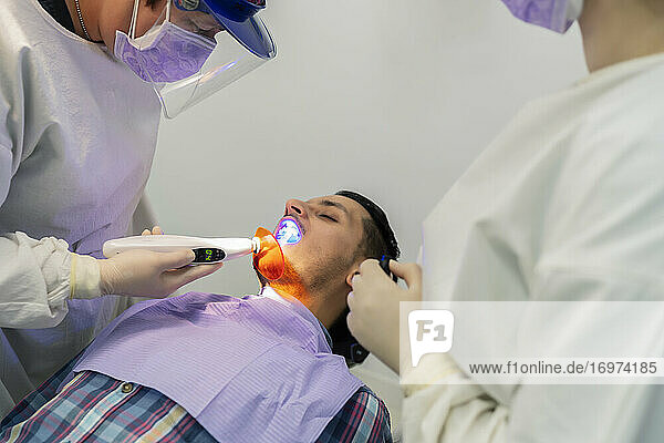 Zahnarzt  der einen Zahn eines Patienten füllt