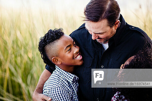 Vater und Söhne umarmen sich im Park in Chula Vista