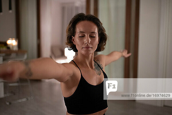 Junge Frau macht Yoga mit geschlossenen Augen