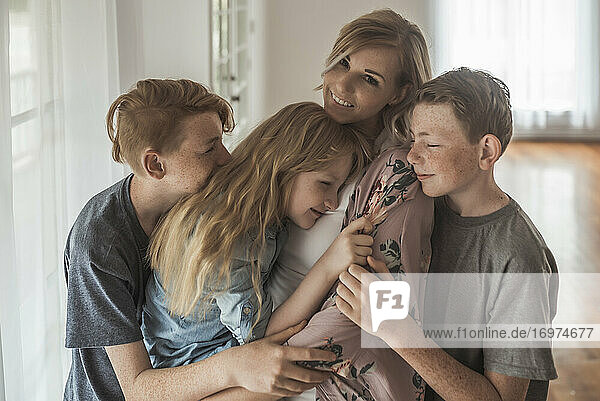Family portrait of beautiful family with red hair embracing in studio