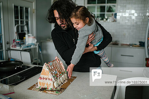 Vater und Tochter bewundern das fertige Pfefferkuchenhaus