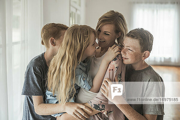 Familienporträt einer schönen Familie mit roten Haaren  die sich im Studio umarmt