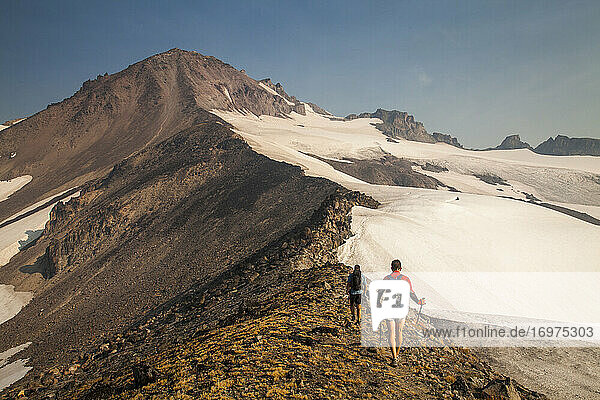 Two hikers climb towards the summit of Glaicer Peak in Washington.