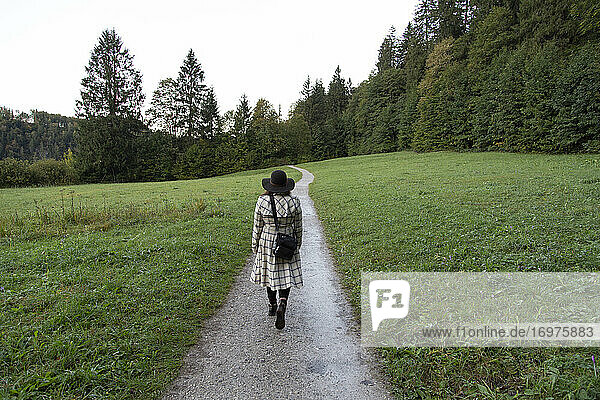 Eine Frau geht auf einem Waldweg in Deutschland spazieren