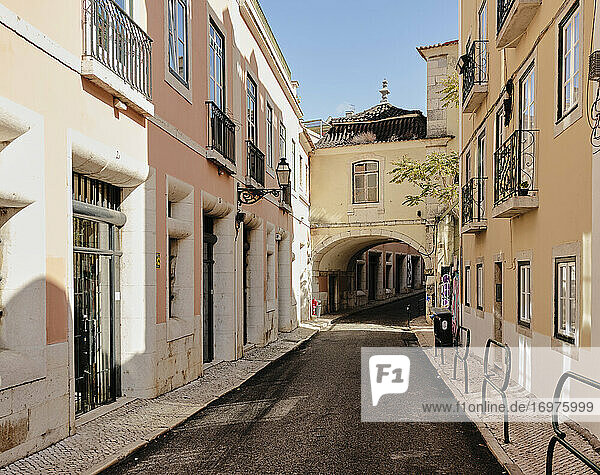 Enge Straße  die zu einem Bogen in Lissabon führt