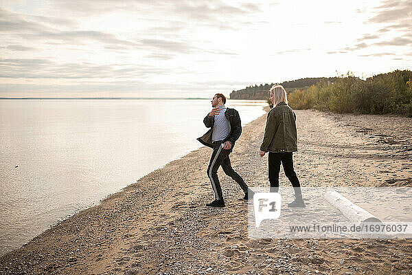 Young couple playing on lake coast