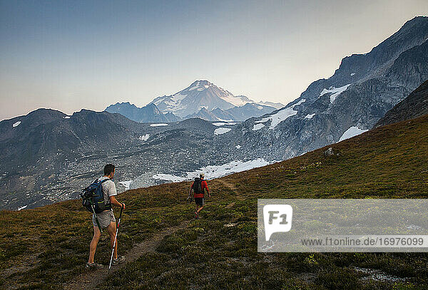 Two hikers climb towards the summit of Glaicer Peak in Washington.