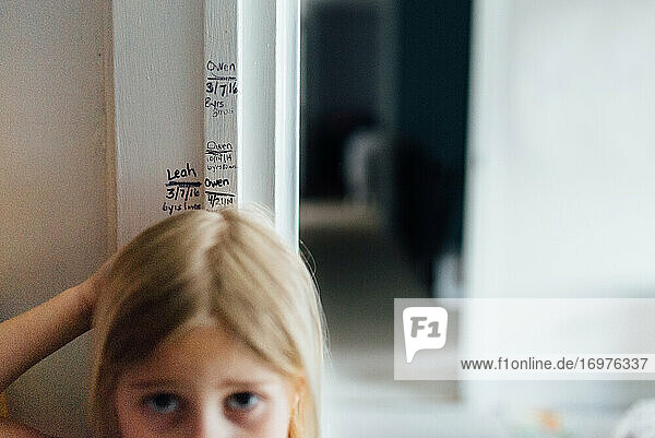 Messung der Größe eines Mädchens zu Hause am Türrahmen