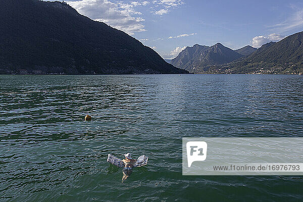 Eine Frau schwimmt auf einem Floß in der Mitte des Iseo-Sees in Italien