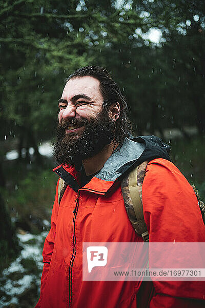 Bärtiger Mann in der Natur an einem verschneiten Tag lächelt glücklich