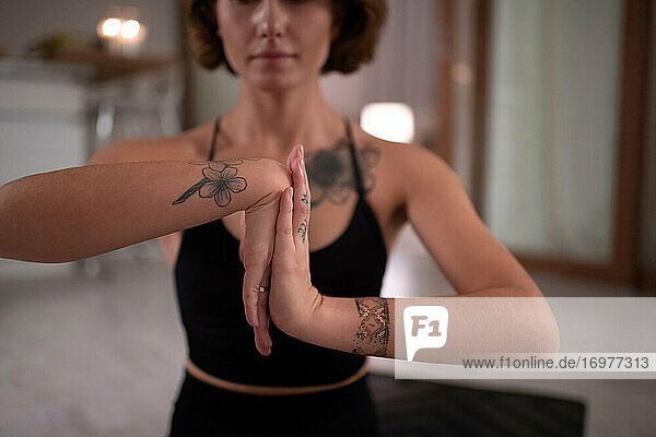 Beschnittene Yoga-Praktizierende streckt die Hände
