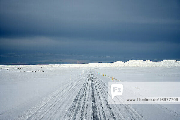 Verschneite Straße in winterlicher Landschaft