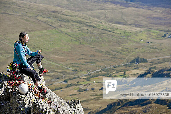 female rock climber enjoying a sandwich on Tryfan in North Wales