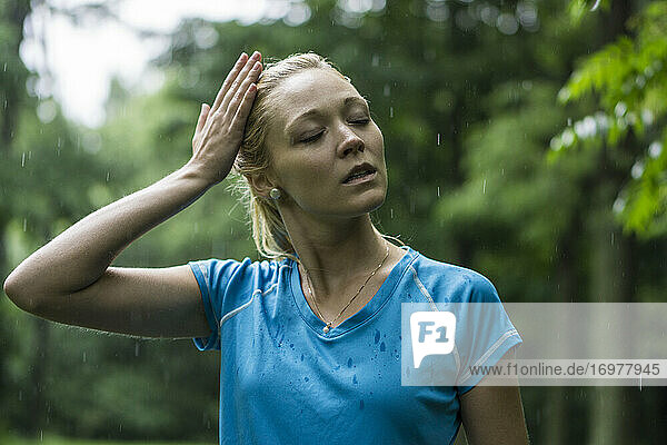 Junge Frau geht im Regen joggen