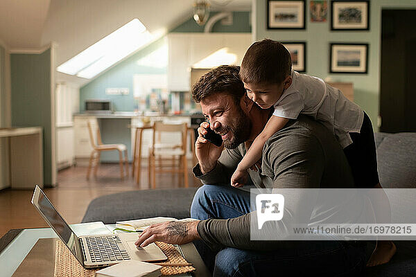 Cheerful father with son working from home