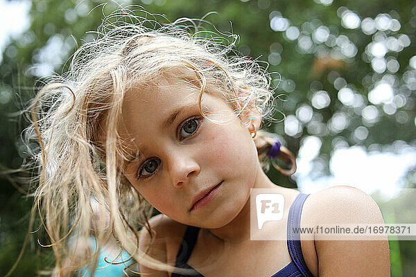Porträt eines Mädchens  das mit ernstem Gesichtsausdruck in die Kamera schaut  Nahaufnahme