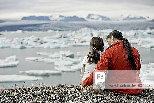 Mutter und Tochter betrachten eine Gletscherlagune in Island