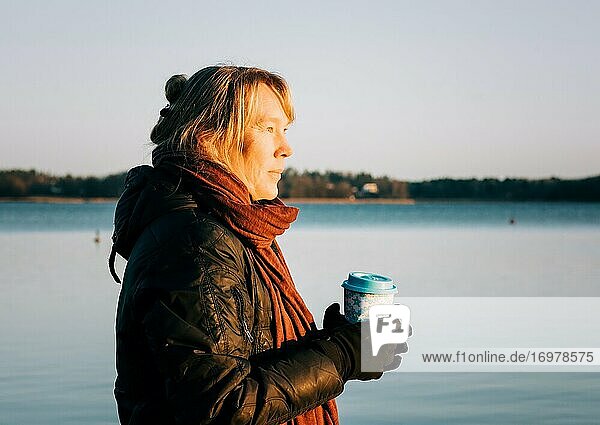 Schwedin mit einem heißen Getränk in der Hand nach dem Schwimmen im kalten Wasser