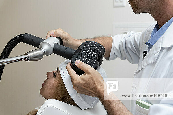 ein Arzt behandelt einen Patienten wegen Kopfschmerzen