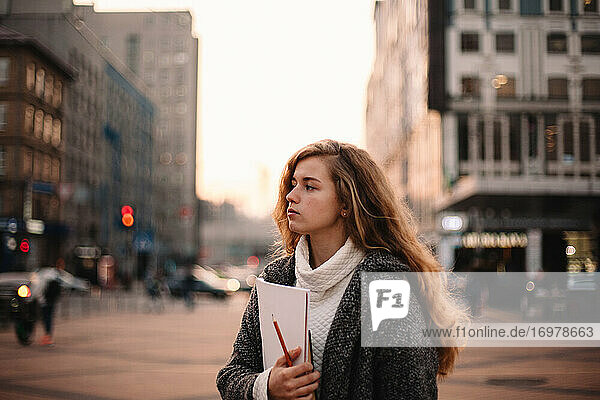 Porträt eines Mädchens im Teenageralter  das im Herbst in der Stadt steht