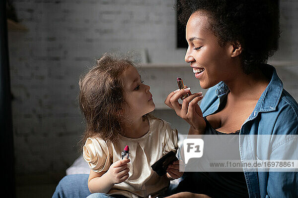 Mutter bringt ihrer Tochter bei  wie man Lippenstift aufträgt