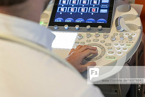 Aufnahme der Hand eines Pflegers  der die Tastatur eines Ultraschallgeräts bedient