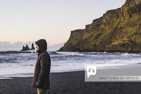 Young traveler watching a sunrise in Vik
