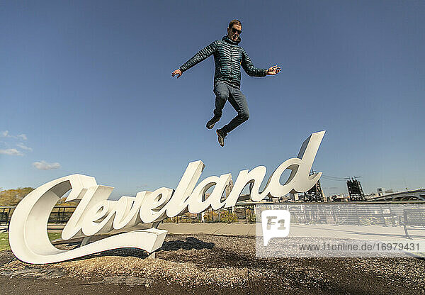 Mann in Daunenjacke springt von Schild in Cleveland  Ohio