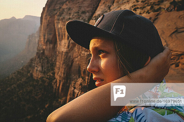 Junge im Hawaiihemd überblickt den Wüstencanyon bei Sonnenuntergang.